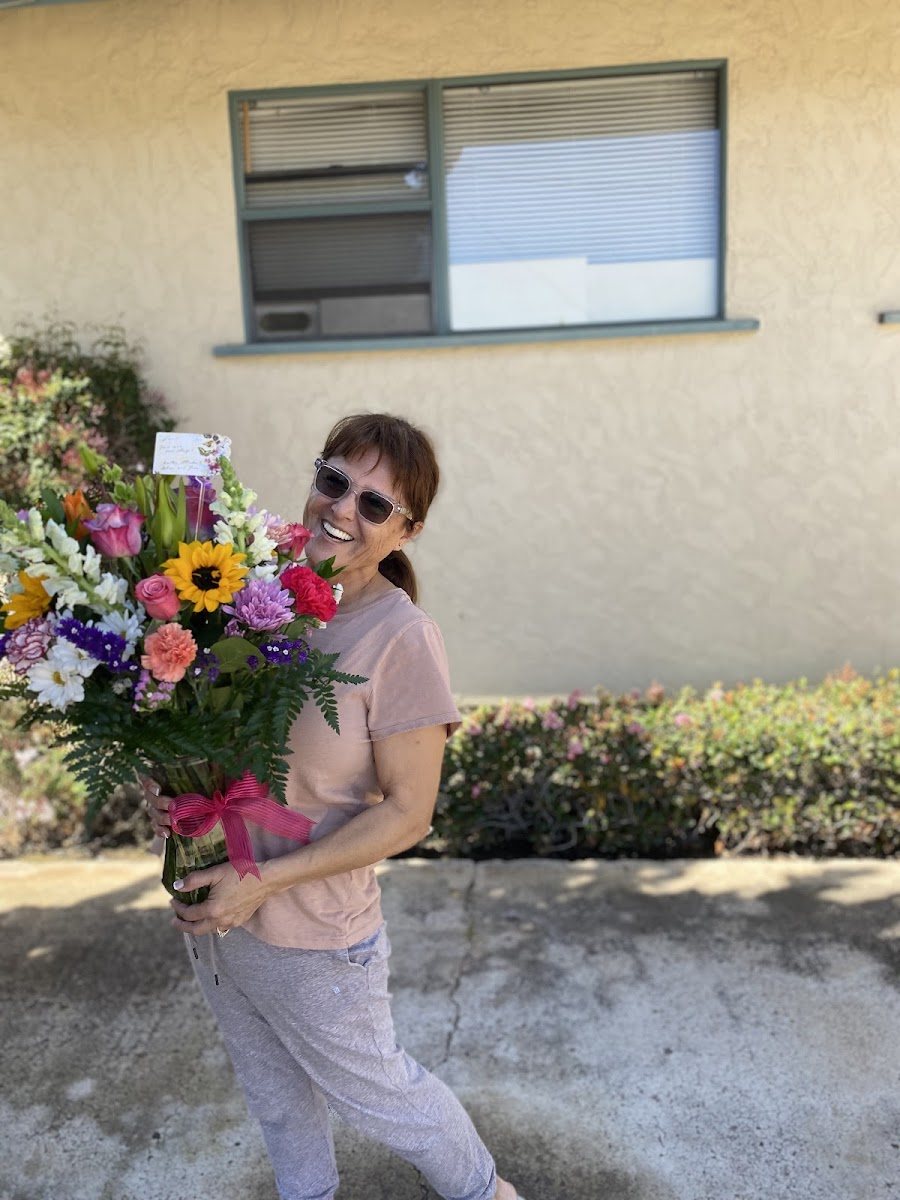 Happy recipient holding a colorful bouquet